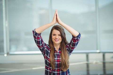 Young Woman Celebrates Victory in Sports Hall with Arms Raised