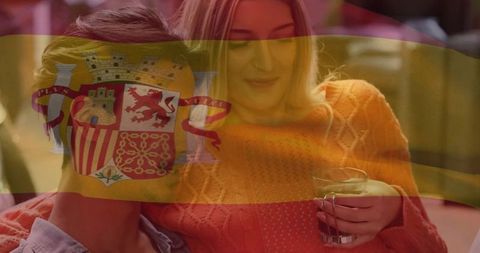 Intimate couple relaxing at home with spanish flag overlay