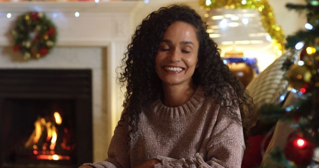 Smiling Woman Sitting Near Fireplace During Holiday Season - Download Free Stock Images Pikwizard.com