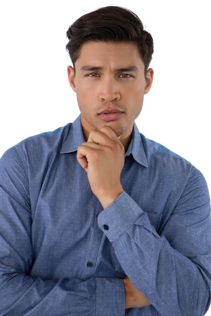 Businessman posing with hand on chin, wearing a blue shirt, isolated against a white background. Ideal for use in corporate presentations, business websites, professional profiles, and marketing materials to convey professionalism, confidence, and thoughtful decision-making.