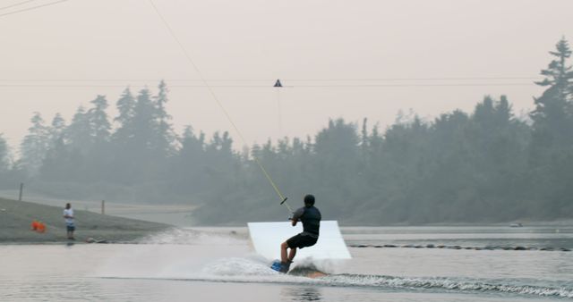 Man Wakeboarding on Lake at Twilight with Rope Tow - Download Free Stock Images Pikwizard.com