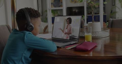 Child Learning Online With Headphones in Stylish Dining Room