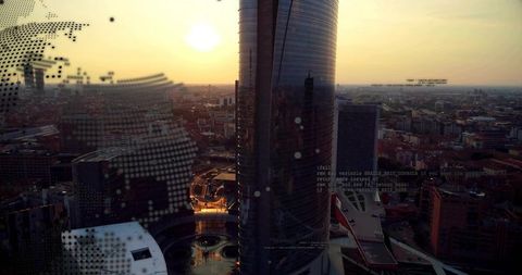 Glass tower reflecting sunset over urban plaza with fountain and halftone overlay