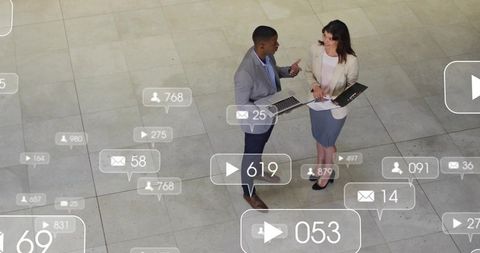 Business colleagues discussing digital analytics and social media overlays in modern atrium