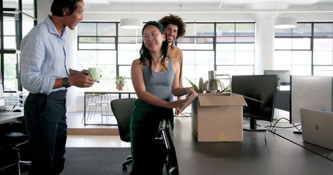 Colleagues unpacking office box, bonding and communication