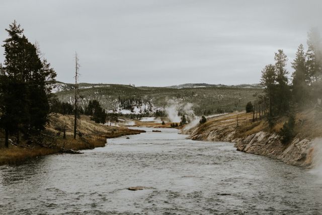 Serene River Flowing Through Rocky Valley with Distant Steam - Download Free Stock Images Pikwizard.com