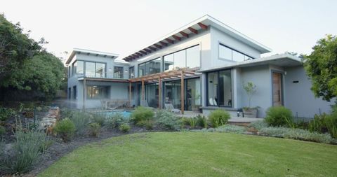 Contemporary two-story glass residence with pergola, pool and landscaped backyard oasis