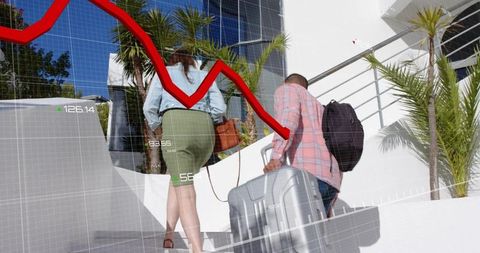 Business travelers climbing stairs with luggage under red downward market graph