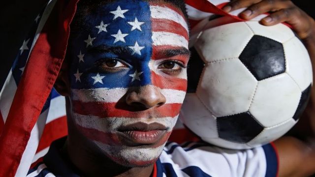 American soccer fan holding ball with full us flag face paint portrait, dramatic lighting