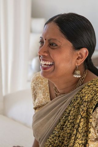 Joyful indian woman laughing in traditional sari at home