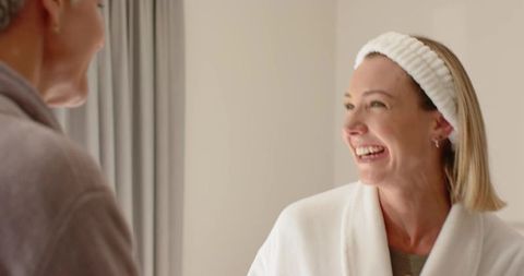 Mother and daughter sharing laugh during morning self-care routine at home