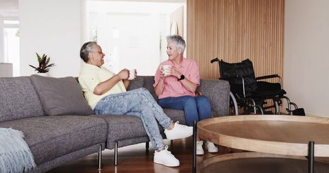 Multiracial senior couple enjoying coffee at home