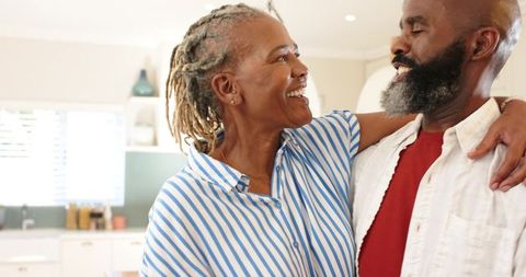 Couple Embracing and Smiling in Modern Kitchen at Home