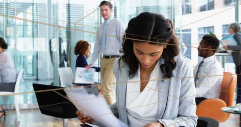 Businesswoman Analyzing Documents in Modern Office