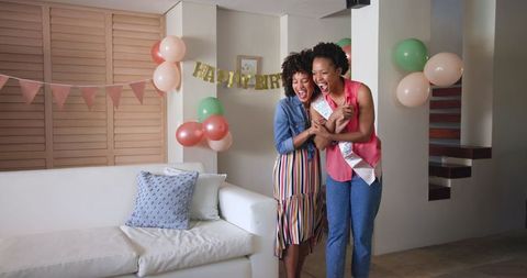 Smiling Diverse Female Couple Celebrating Birthday Together at Home