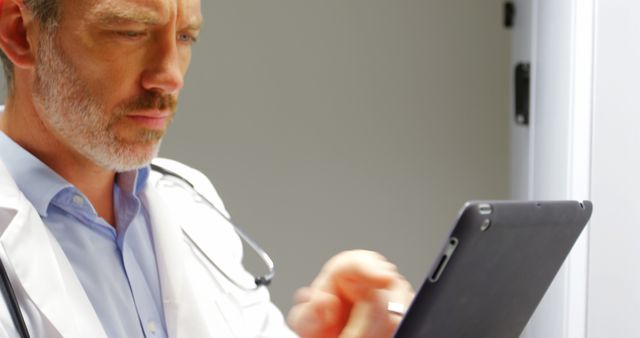 Mature doctor using tablet for medical records - Download Free Stock Images Pikwizard.com