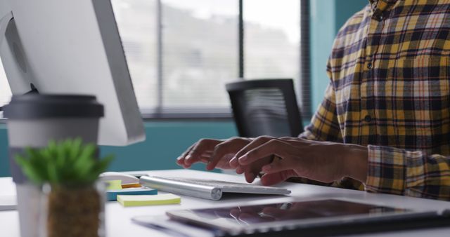 Person Typing on Computer in Office Workspace with Plants and Coffee - Download Free Stock Images Pikwizard.com