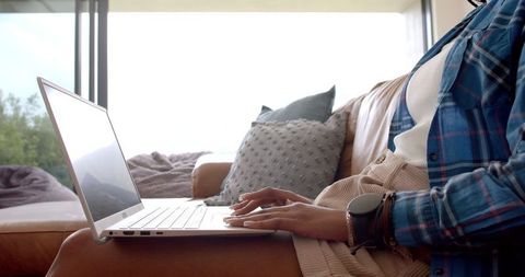 Young Professional Typing on Laptop in Cozy Living Room