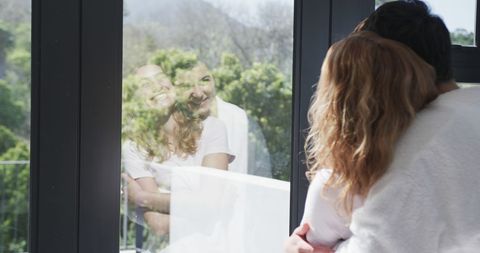 Joyful Lesbian Couple Embracing by Sunny Window
