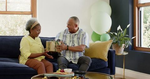 Joyful Senior Couple Celebrating with Gift Exchange
