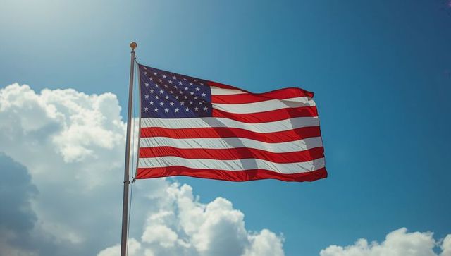 United States Flag Waving Against Bright Blue Sky