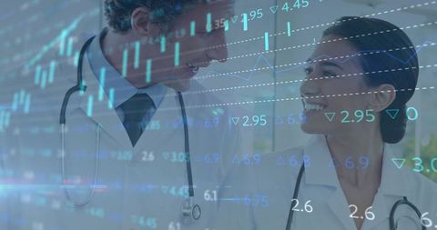 Smiling Doctors Collaborating Over Medical Analytics and Financial Charts in Hospital Ward