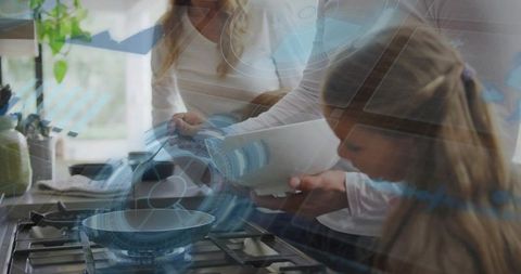 Mother pouring batter into pan while daughter watching in sunlit cozy kitchen