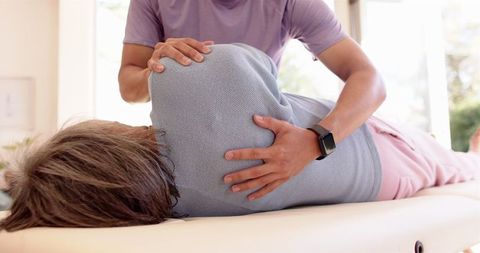 Senior therapy: physiotherapist assisting elderly patient with mobility recovery