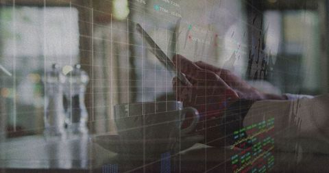 Businessman analyzing stocks on tablet with cafe ambience