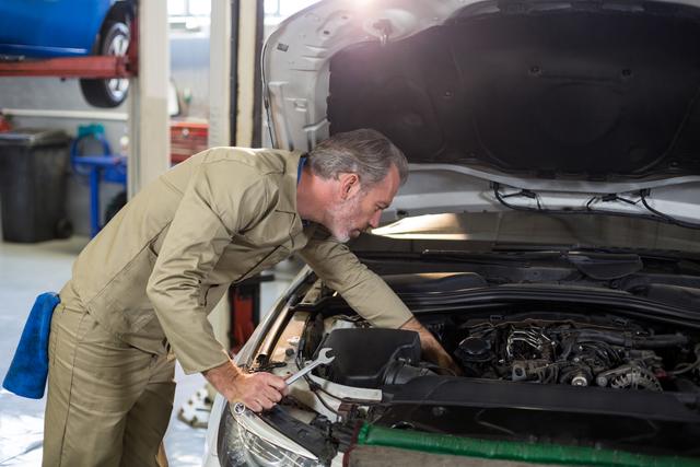 Mechanic servicing a automobile car engine at repair shop