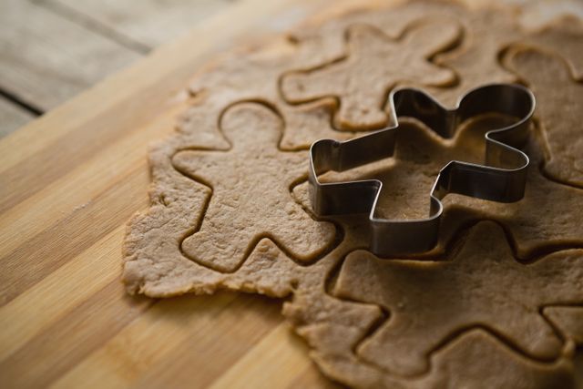 Perfect for holiday-themed content, this image showcases a gingerbread man cookie cutter on rolled dough, ideal for Christmas baking articles, festive recipe blogs, or kitchen decor inspiration.