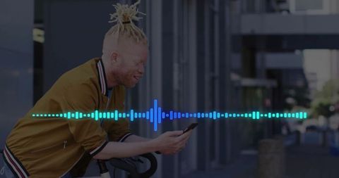 Man in urban setting enjoys digital content on phone while biking