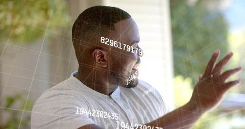 Smiling man interacting with augmented reality numeric grid on modern patio