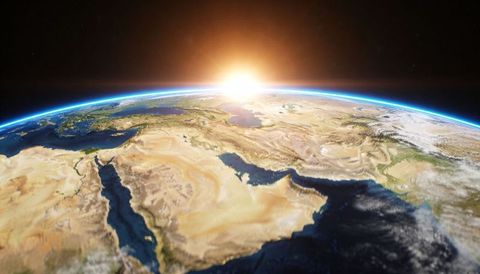 Sun rising over middle east from orbit showing thin blue atmospheric rim and red sea