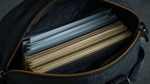 Open bag with documents on grey office desk