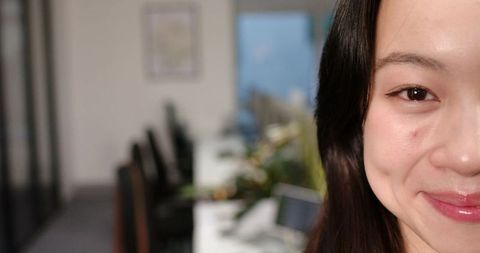 Asian woman smiling in modern open-plan office