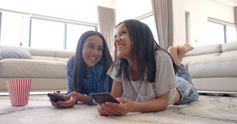 Teenage Friends Laughing While Using Smartphones at Home - Download Free Stock Images Pikwizard.com