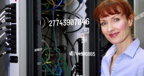 Redhead IT Technician Checking Server Rack with Numeric Data Overlay and Colorful Cabling