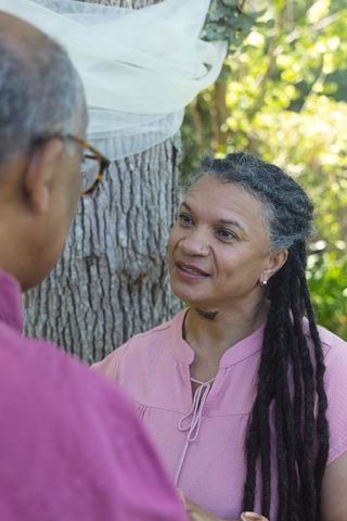 African american couple sharing intimate conversation outdoors by tree in soft sunlight