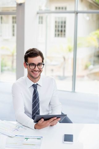 Business Professional in Bright Modern Office Holding Tablet