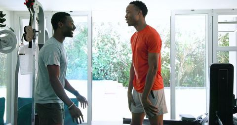 Two Friends Enjoy Fitness Routine Together Home Gym Equipped