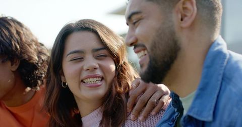 Three Friends Laughing Together Outdoors Close-Up Portrait Showing Joy and Connection