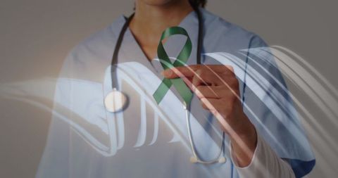 Nurse holding green awareness ribbon wearing stethoscope with abstract digital overlay