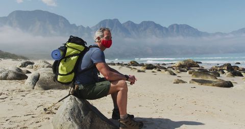 Senior Explorer Resting on Beach With Backpack and Mask - Download Free Stock Images Pikwizard.com