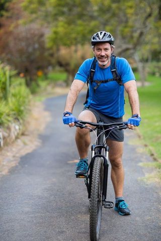 Man enjoying mountain biking adventure on scenic park path