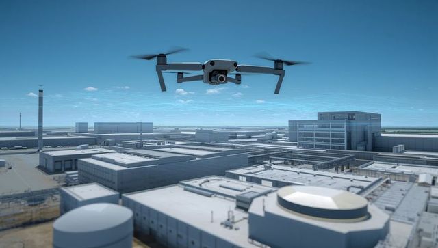 Industrial drone hovering over factory rooftops monitoring facility with camera gimbal