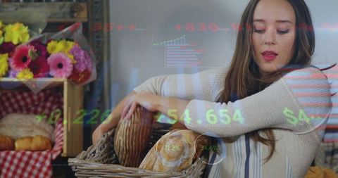 Artisan baker arranging fresh loaves in wicker basket rustic market counter display