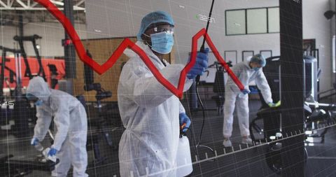 Specialists in protective gear implementing hygiene protocols in modern gym