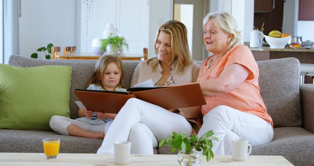 Caucasian family enjoys reading at home, with copy space. Senior woman shares a story with a young girl and her mother, creating a warm, educational moment.