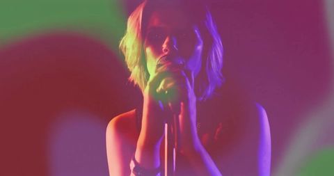 Dynamic Teen Singer Embraced by Vivid Stage Lighting